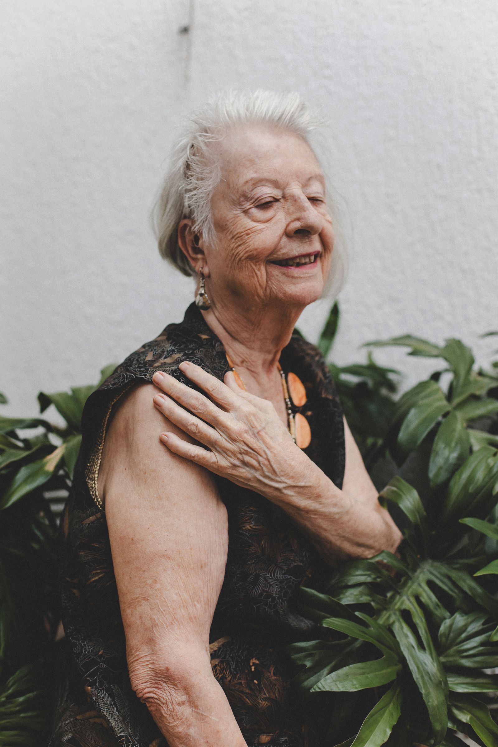 A smiling Sarasota retiree relaxing among green plants